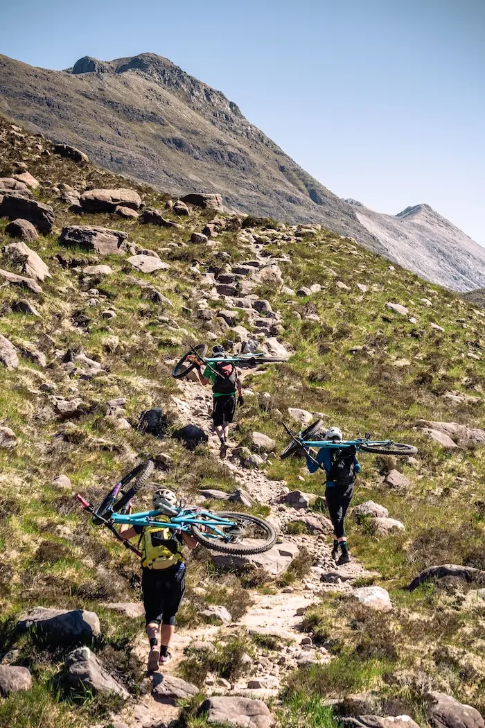 Coast-to-coast Scotland mountain bike tour, riders hiking with their bikes