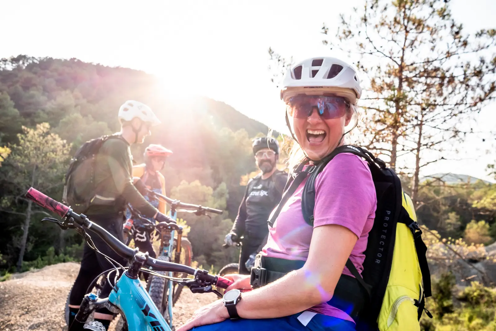 Female mountain biker laughing with friends in the Pyrenees